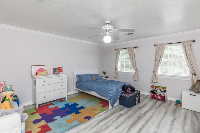 bedroom with crown molding, a textured ceiling, visible vents, and wood finished floors