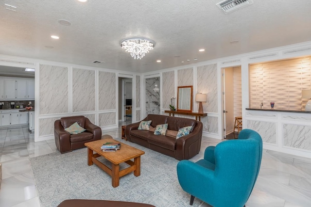 living area with an inviting chandelier, recessed lighting, a textured ceiling, and visible vents