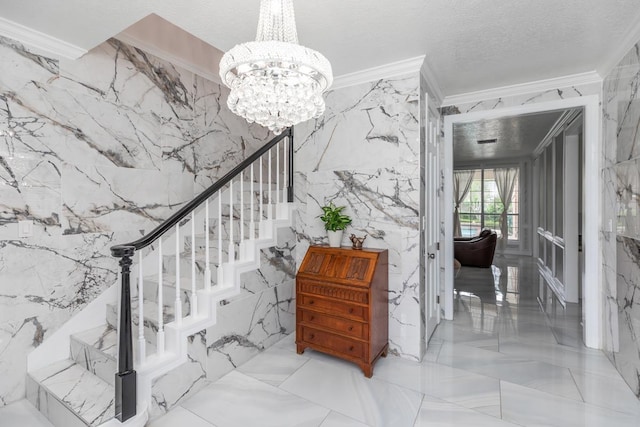 staircase featuring an inviting chandelier, ornamental molding, marble finish floor, and stone wall