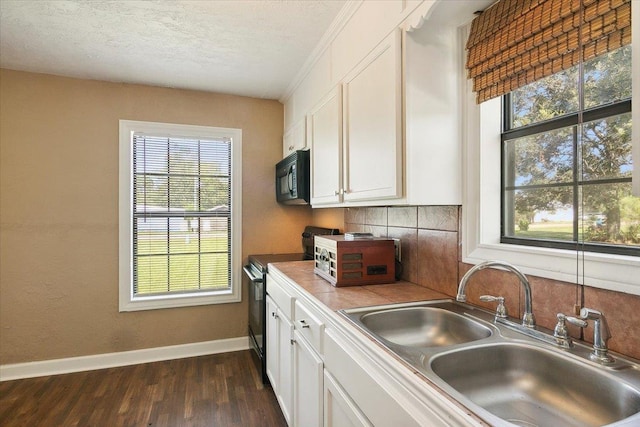 209 Boutwell Rd, Beaumont, TX 77713 - kitchen with electric range, black microwave, a sink, and white cabinetry