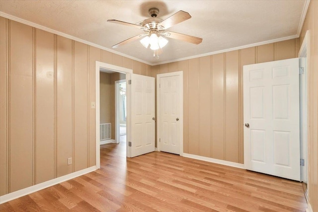 209 Boutwell Rd, Beaumont, TX 77713 - unfurnished bedroom with ornamental molding, light wood-style flooring, baseboards, a ceiling fan, and a decorative wall