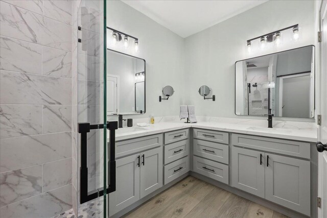 1326 Emerald Dr, Port Bolivar, TX 77650 - bathroom with double vanity, wood finished floors, and a shower with shower door