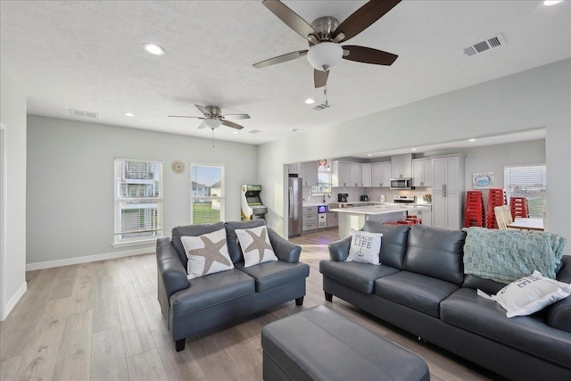 1326 Emerald Dr, Port Bolivar, TX 77650 - living room featuring recessed lighting, ceiling fan, light wood-type flooring, and a textured ceiling
