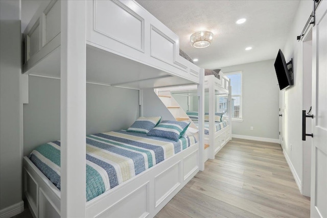 1326 Emerald Dr, Port Bolivar, TX 77650 - bedroom featuring light wood finished floors, recessed lighting, and a textured ceiling