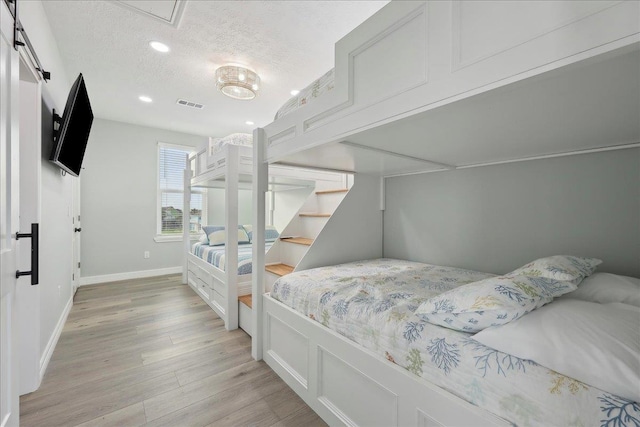 1326 Emerald Dr, Port Bolivar, TX 77650 - bedroom featuring light wood finished floors, a textured ceiling, and recessed lighting