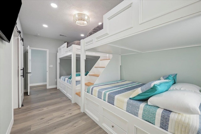 1326 Emerald Dr, Port Bolivar, TX 77650 - bedroom featuring light wood-style flooring, recessed lighting, and a textured ceiling