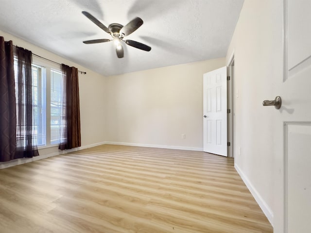 spare room with ceiling fan, light hardwood / wood-style flooring, a healthy amount of sunlight, and a textured ceiling