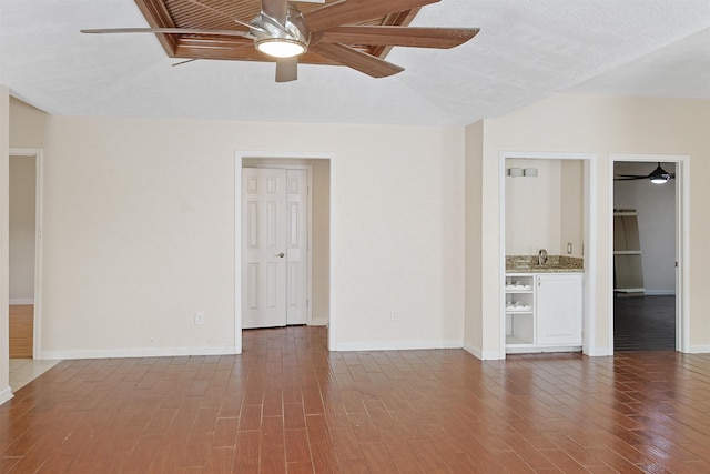 spare room with sink, dark hardwood / wood-style flooring, and a textured ceiling