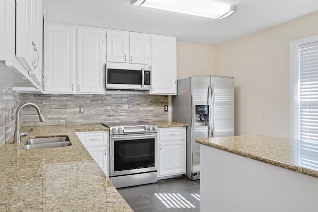 kitchen with decorative backsplash, sink, white cabinets, and stainless steel appliances