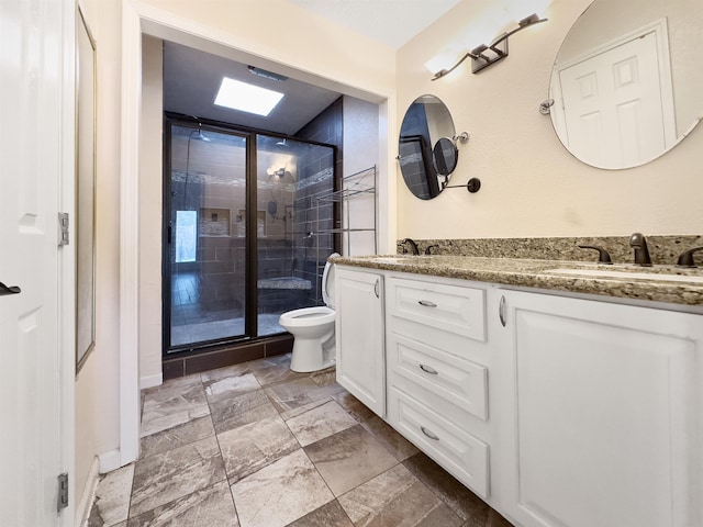 bathroom featuring a shower with door, vanity, and toilet