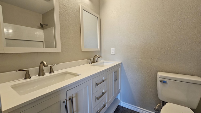 bathroom featuring vanity, toilet, and walk in shower