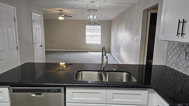 kitchen featuring decorative light fixtures, white cabinetry, stainless steel dishwasher, and sink