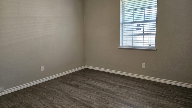 unfurnished room with dark hardwood / wood-style flooring