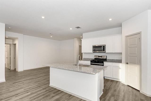 kitchen with stainless steel appliances, white cabinetry, a kitchen island with sink, and sink