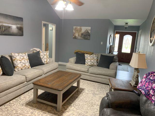 living room featuring ceiling fan and vaulted ceiling