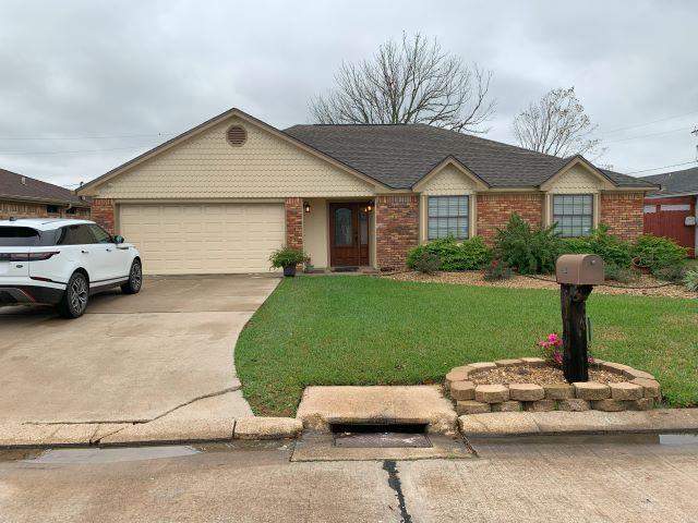 ranch-style home with a front lawn and a garage