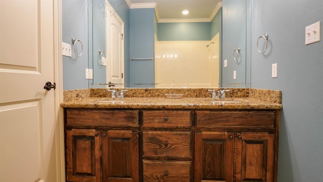 full bathroom with double vanity, crown molding, and a sink