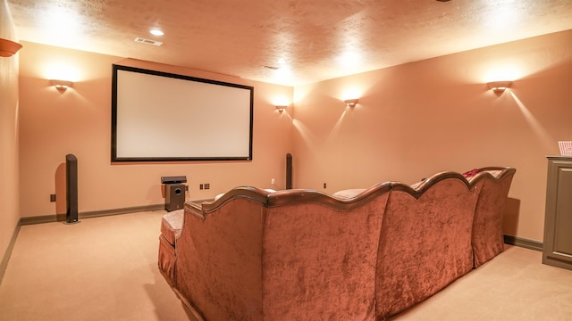 cinema featuring a textured ceiling, visible vents, baseboards, and light carpet