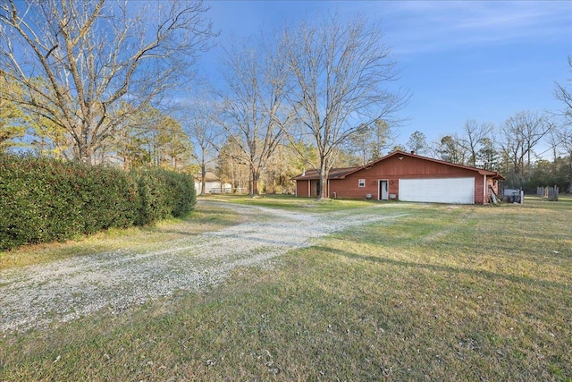 view of side of home featuring a garage, driveway, and a yard