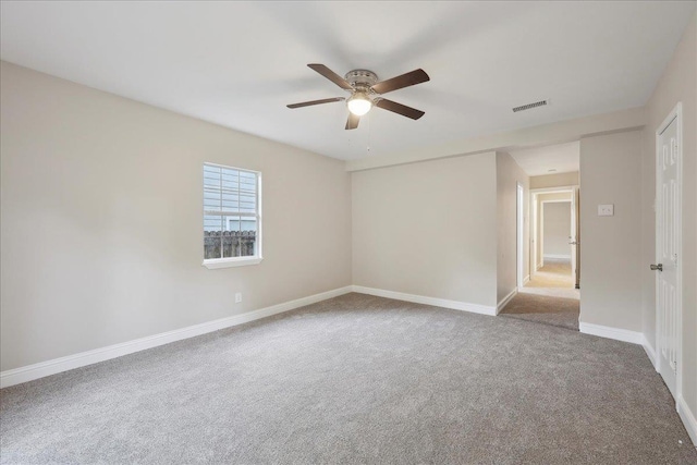 empty room featuring carpet floors, ceiling fan, baseboards, and visible vents