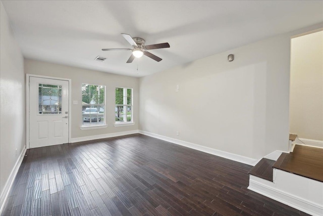 spare room with baseboards, ceiling fan, dark wood-style floors, and visible vents
