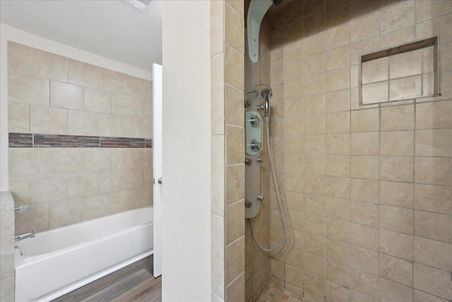 bathroom featuring a bath and tiled shower