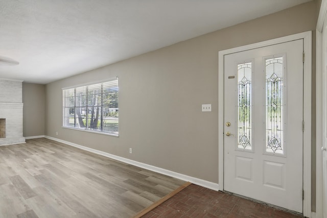 entryway with a fireplace and light hardwood / wood-style flooring