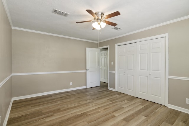 unfurnished bedroom featuring a closet, ceiling fan, crown molding, and light hardwood / wood-style flooring