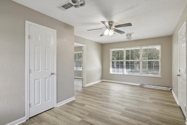 unfurnished room with ceiling fan, light hardwood / wood-style floors, and a wealth of natural light