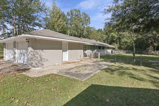 view of home's exterior with a garage and a lawn