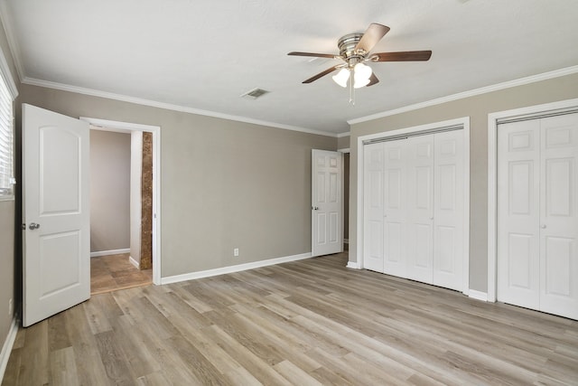 unfurnished bedroom featuring multiple closets, ceiling fan, light hardwood / wood-style flooring, and ornamental molding