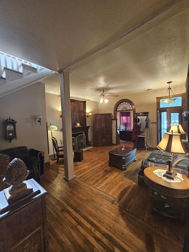 living room with a wood stove, ceiling fan, french doors, dark hardwood / wood-style flooring, and a textured ceiling