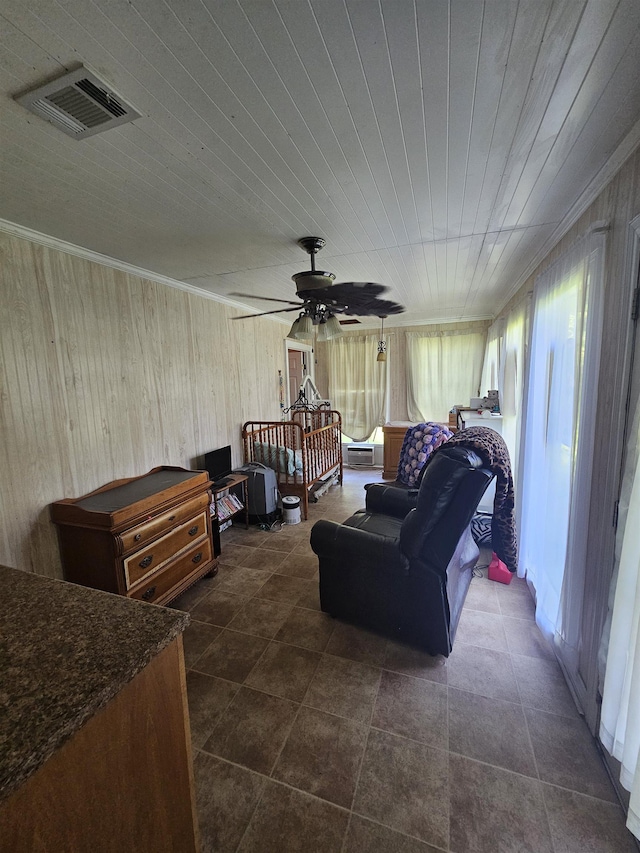 living room featuring plenty of natural light, ceiling fan, crown molding, and wooden walls