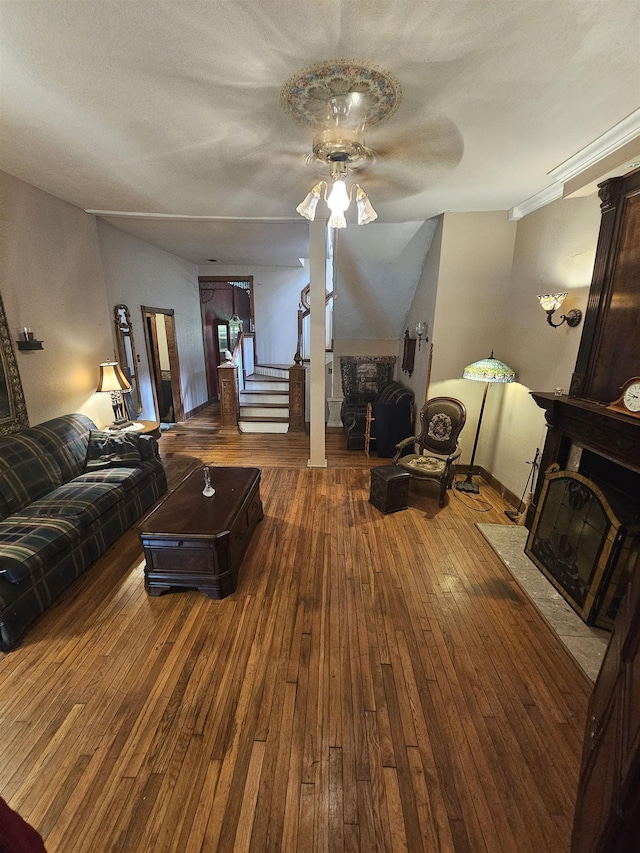 living room featuring ceiling fan, a fireplace, and hardwood / wood-style flooring