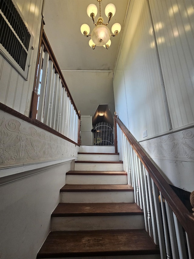 stairway featuring a chandelier