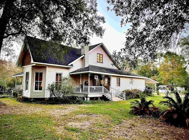 rear view of house with a lawn and covered porch