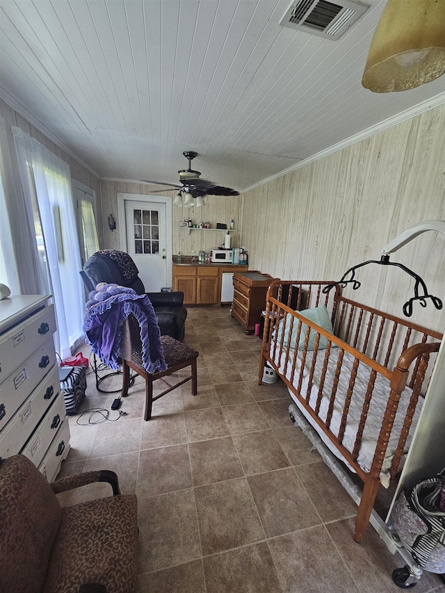 bedroom featuring ceiling fan, wooden ceiling, ornamental molding, and wooden walls