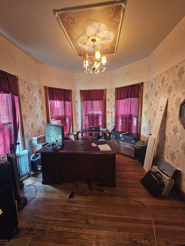 home office with radiator heating unit, dark wood-type flooring, and an inviting chandelier