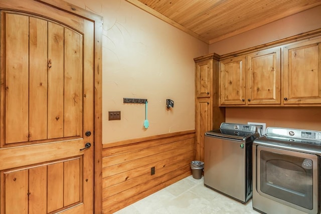 laundry room featuring cabinets, washer and clothes dryer, wooden walls, light tile patterned floors, and wooden ceiling