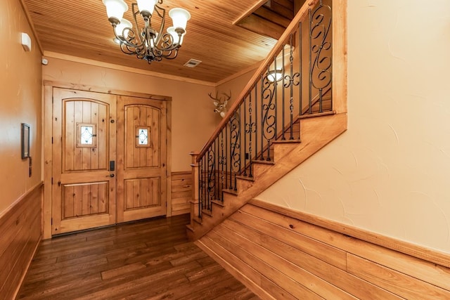 entrance foyer featuring wood ceiling, crown molding, an inviting chandelier, dark hardwood / wood-style floors, and wood walls