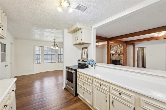 kitchen featuring decorative light fixtures, a chandelier, a textured ceiling, dark hardwood / wood-style floors, and electric stove