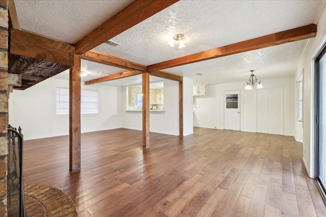 basement featuring hardwood / wood-style floors, a notable chandelier, and a textured ceiling