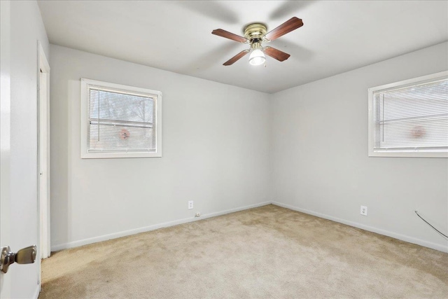 unfurnished room featuring plenty of natural light, light colored carpet, and ceiling fan