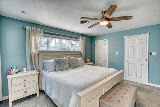 carpeted bedroom with ceiling fan and a textured ceiling