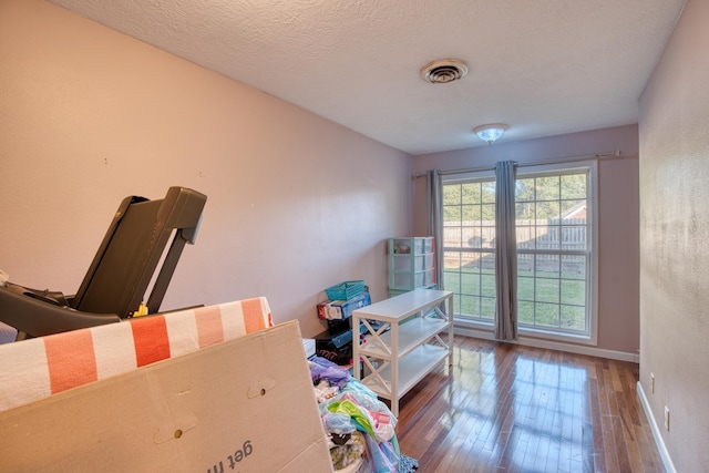 misc room featuring wood-type flooring and a textured ceiling