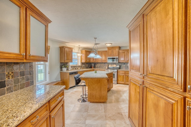 kitchen featuring decorative backsplash, a breakfast bar, stainless steel appliances, a kitchen island, and hanging light fixtures