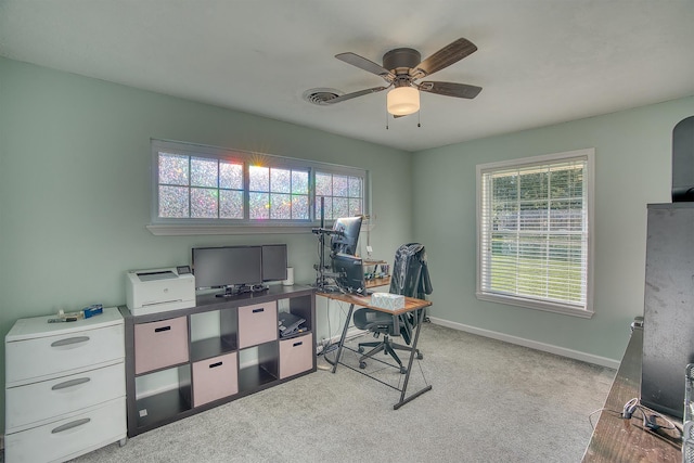 home office featuring light carpet, plenty of natural light, and ceiling fan