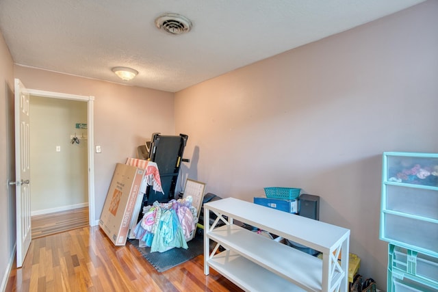 miscellaneous room featuring a textured ceiling and hardwood / wood-style flooring