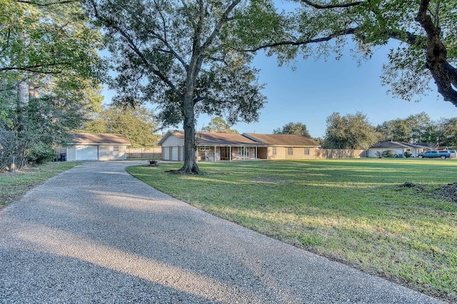 ranch-style house featuring an outbuilding, a garage, and a front lawn