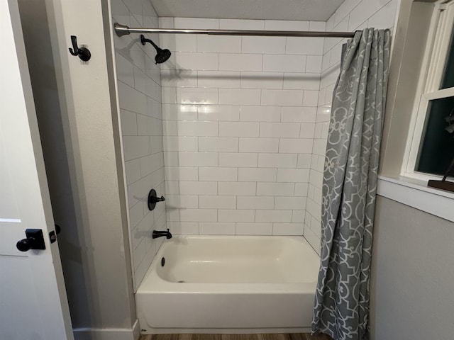 full bath with shower / bath combo with shower curtain and wood finished floors